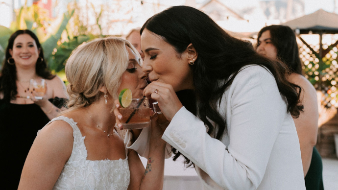 LGBTQ couple sharing a toast with craft cocktails at FruitCraft’s distillery bar in San Diego.