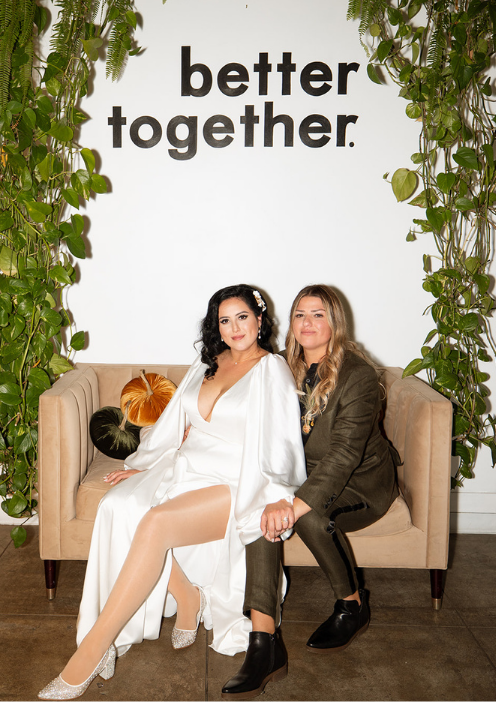 LGBTQ couple seated at the “Better Together” couch lounge setup during their FruitCraft wedding celebration.